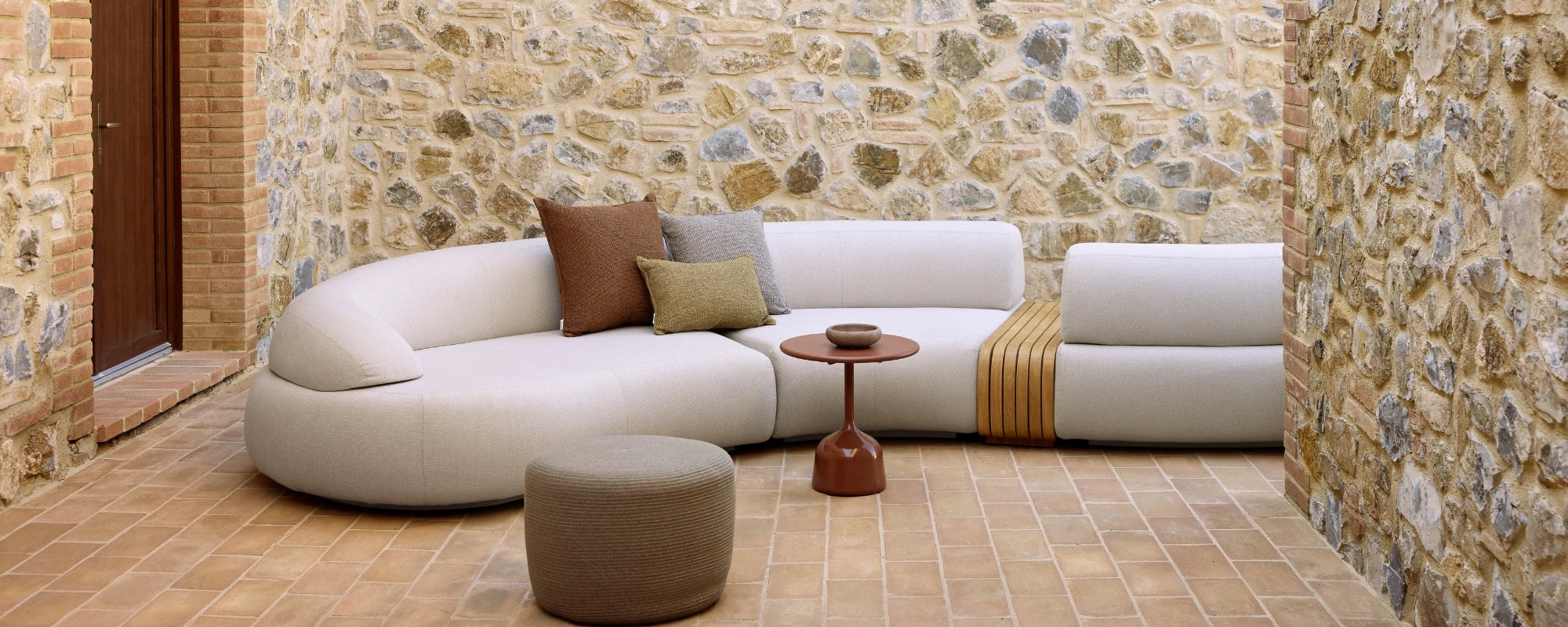 Cane Line Mellow Curved Outdoor Sofa on Terrace in Light Grey with soft cushions